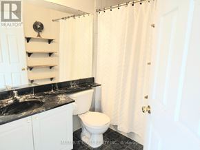 Toronto (Niagara) townhouse for rent - A white bathroom with a black counter top and a white toilet.