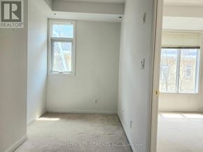 Toronto (Niagara) townhouse for rent - A white room with a window and a door leading to another room.