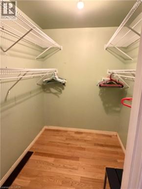Kitchener apartment for rent - A walk in closet with white shelving and a wooden floor.