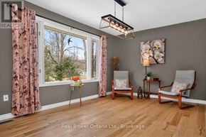 Tiny apartment for rent - A room with a window, two chairs, and a table with a vase of flowers.