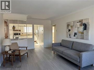 Brantford apartment for rent - A living room with a grey couch and a wooden table.