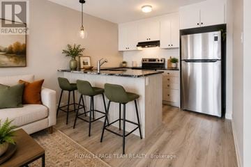 Ottawa townhouse for rent - A modern kitchen with a refrigerator, sink, and bar stools.