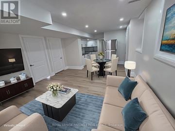Milton (Cb Cobban) apartment for rent - A living room with a beige sofa, a coffee table, and a painting on the wall.