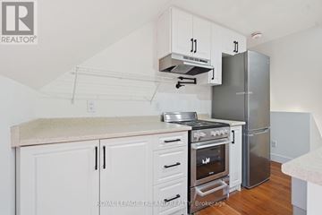 St. Thomas multi-family for rent - A kitchen with white cabinets and a stainless steel refrigerator.
