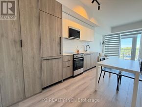 Toronto (Centennial Scarborough) condo for rent - A kitchen with wooden cabinets and a white table.
