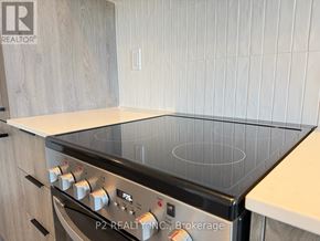 Toronto (Centennial Scarborough) condo for rent - A modern kitchen with a stove top oven and wooden cabinets.