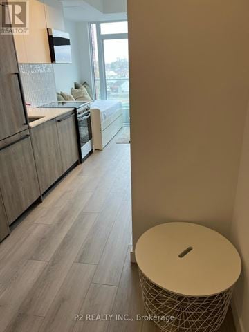 Toronto (Centennial Scarborough) condo for rent - A modern kitchen with wooden cabinets and a large window.