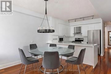 Toronto (Waterfront Communities) condo for rent - A modern kitchen with a glass table and grey chairs.