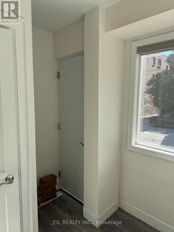 Toronto (Roncesvalles) multi-family for rent - A hallway with a door and a window.