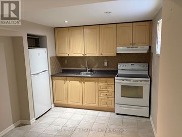 Mississauga (Cooksville) apartment for rent - A kitchen with a white refrigerator, brown cabinets, and a white stove top oven.