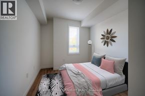Kitchener condo for rent - A bedroom with a bed, pillows, and a ceiling fan.
