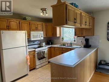 Alfred And Plantagenet apartment for rent - A kitchen with wooden cabinets and a white refrigerator.