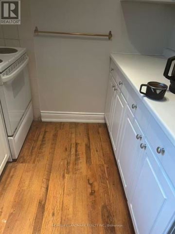 Toronto (The Beaches) triplex for rent - A kitchen with a white dishwasher and wooden floors.