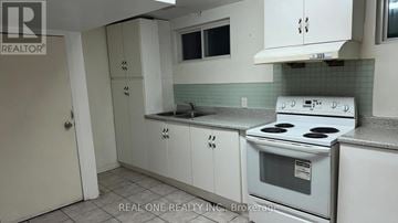 Mississauga (Mississauga Valleys) apartment for rent - A white stove is in a kitchen with white cabinets.