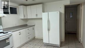 Mississauga (Mississauga Valleys) apartment for rent - A white refrigerator stands in a kitchen with white cabinets and a white stove.