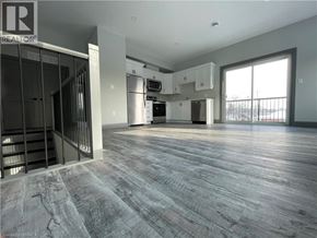 Simcoe apartment for rent - A spacious, empty room with wood flooring and a large window.