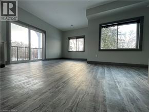 Simcoe apartment for rent - A spacious room with wooden flooring and large windows.