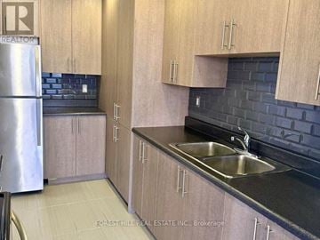 Toronto (Don Valley Village) house for rent - A kitchen with wooden cabinets and a black countertop.