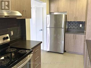 Toronto (Don Valley Village) house for rent - A kitchen with a stove top oven and a refrigerator.