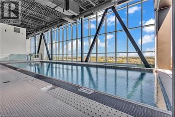 Kitchener condo for rent - A large indoor swimming pool with a view of the sky through the windows.