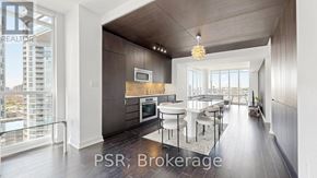 Toronto (Waterfront Communities) condo for rent - A modern kitchen with a dining area and a balcony overlooking the city.