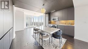 Toronto (Waterfront Communities) condo for rent - A modern kitchen with a dining table and chairs.