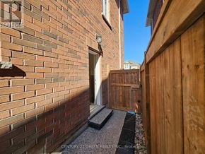 Halton Hills (Georgetown) apartment for rent - A brick wall with a wooden fence and a small doorway.