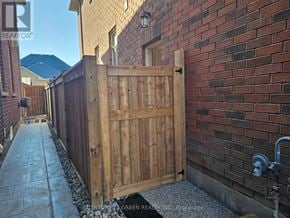 Halton Hills (Georgetown) apartment for rent - A wooden gate is closed at the end of a concrete path.
