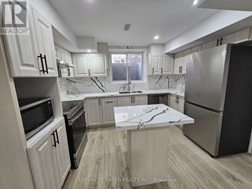 Halton Hills (Georgetown) apartment for rent - A kitchen with wooden cabinets and a marble island.