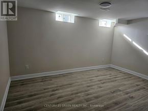 Halton Hills (Georgetown) apartment for rent - A room with wooden flooring and white walls, with a ceiling light and two windows.
