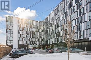 Oshawa (Samac) condo for rent - A modern building with a parking lot in front of it.