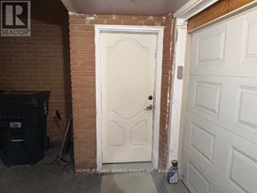 Toronto (L'amoreaux) apartment for rent - A white door with a black trash can to the left and a white garage door to the right.
