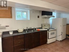 Toronto (L'amoreaux) apartment for rent - A kitchen with brown cabinets and a white refrigerator.