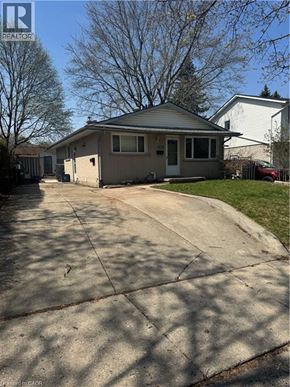 Kitchener apartment for rent - A house with a grey roof and a white fence is for sale.