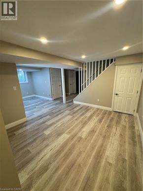 Kitchener apartment for rent - A room with wooden flooring and a staircase leading to another room.