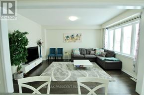 Thorold (Rolling Meadows) apartment for rent - A living room with a grey couch, a white coffee table, and a large window.