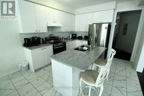 Thorold (Rolling Meadows) apartment for rent - A kitchen with a marble countertop and white cabinets.