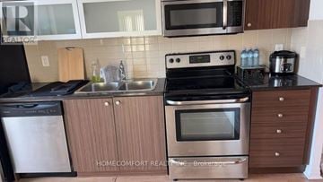 Toronto (Henry Farm) condo for rent - A kitchen with a stove top oven and a dishwasher.