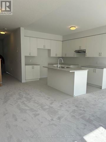 Centre Wellington (Fergus) townhouse for rent - A kitchen with white cabinets and a sink.