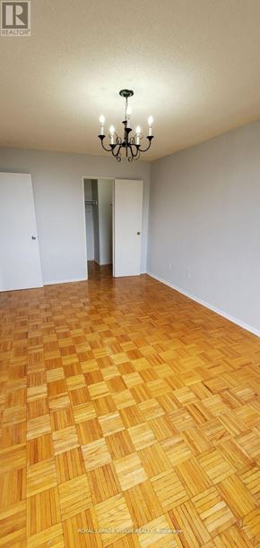 Toronto (Flemingdon Park) condo for rent - A room with a wooden floor and a chandelier.