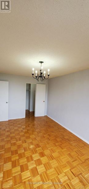 Toronto (Flemingdon Park) condo for rent - A room with a wooden floor and a chandelier.