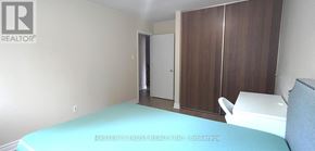 Oakville (Cp College Park) apartment for rent - A bedroom with a bed, wardrobe and a chair.