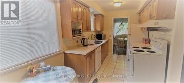 Oakville (Cp College Park) apartment for rent - A kitchen with wooden cabinets and white appliances.