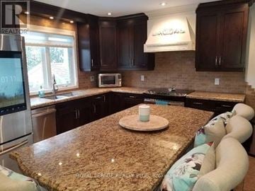 Brampton (Brampton East) apartment for rent - A kitchen with brown cabinets and a granite countertop.