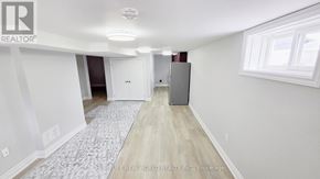 Oshawa (O'neill) apartment for rent - A room with a carpeted floor and a refrigerator in it.