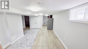 Oshawa (O'neill) apartment for rent - A room with a white ceiling, a grey refrigerator, and a rug on the floor.