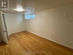 Toronto (Wexford-Maryvale) apartment for rent - A room with wooden flooring and white walls, with a window and a door visible.