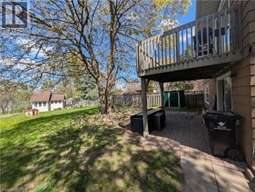 Kitchener apartment for rent - A wooden deck with a black trash can on a patio.