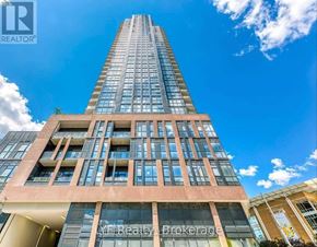 Toronto (Cabbagetown-South St. James Town) condo for rent - A tall building with a glass facade is the focus of this image.