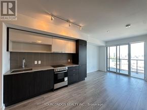 Toronto (Cabbagetown-South St. James Town) condo for rent - A modern kitchen with black cabinets and stainless steel appliances.